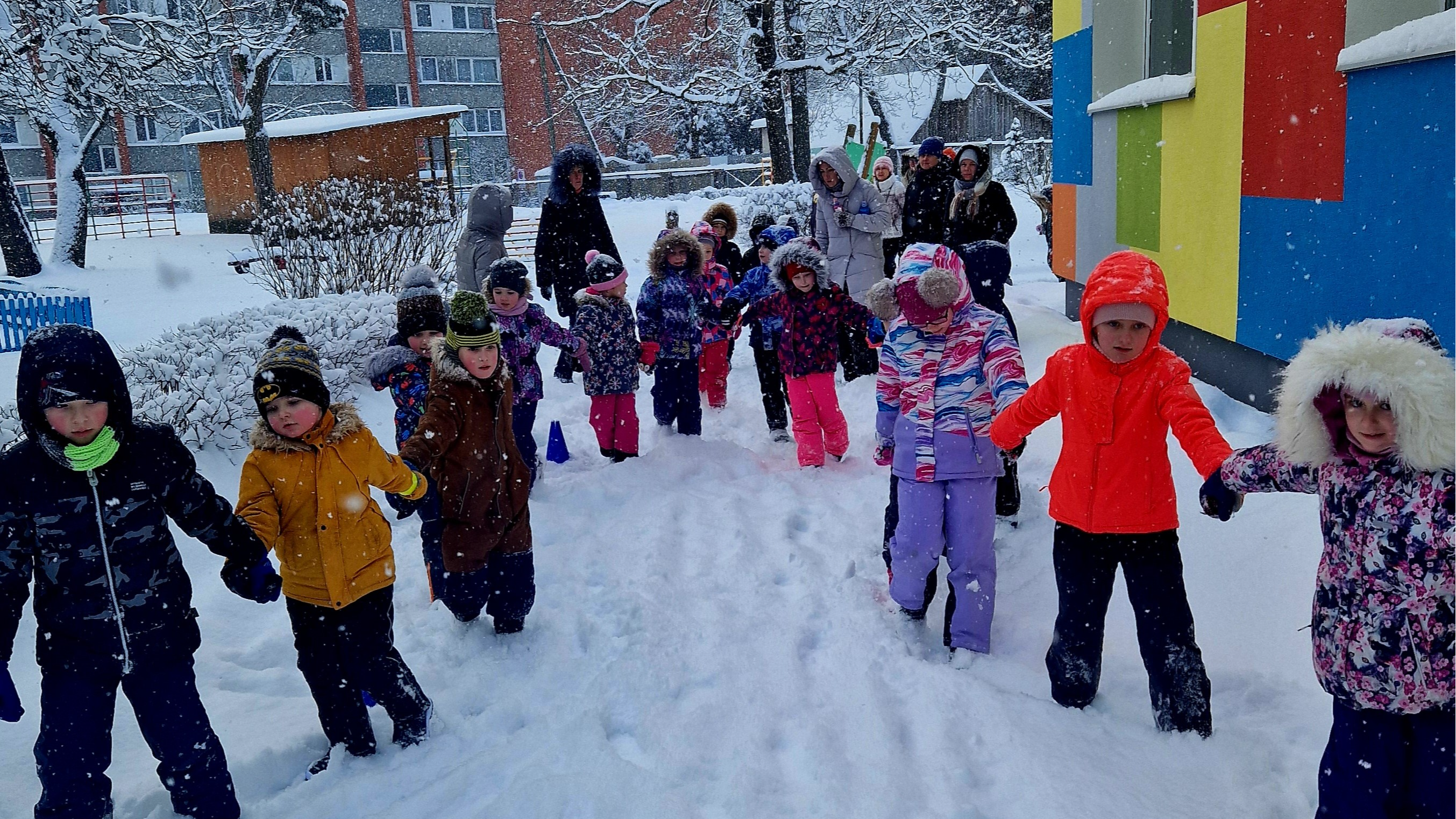 Bērnudārza bērni, rokās sadevušies, dodas uz Ziemas sporta svētkiem