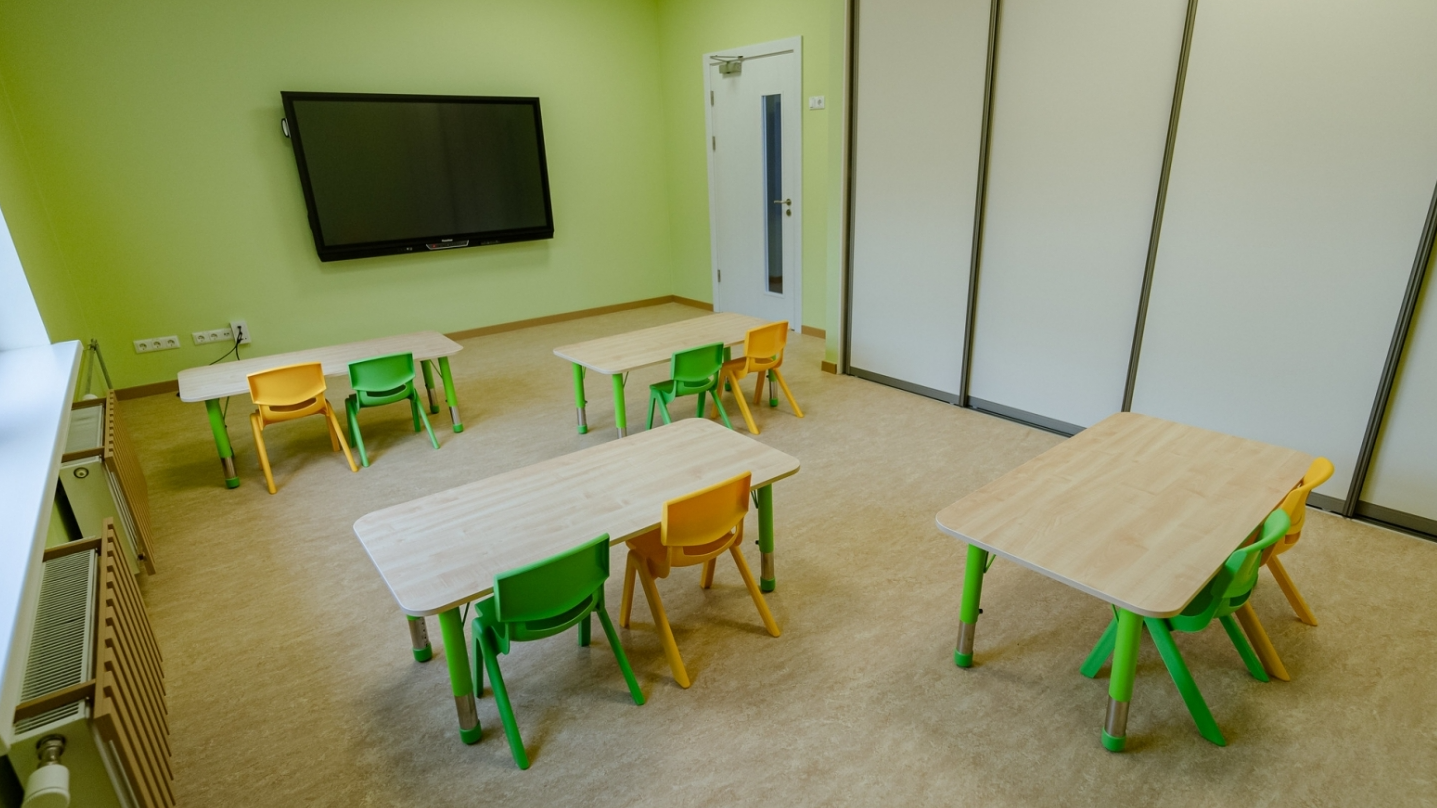 Bērnudārza grupas telpa ar galdiņiem un krēsliņiem