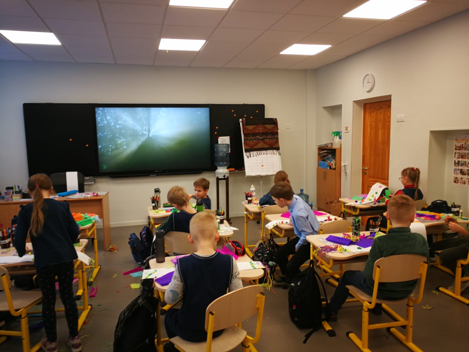 Rīgas 9. vidusskolas 1. A klases bērni dizaina un tehnoloģiju stundā no krāsainiem papīriem gatavo šalles