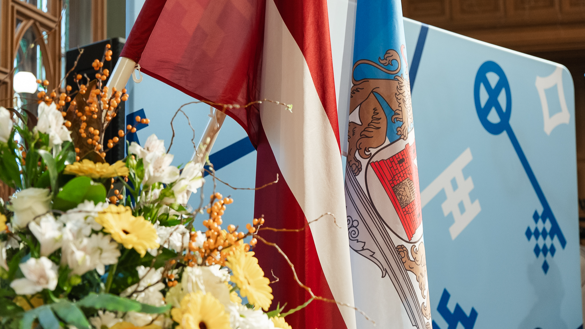 Latvijas valsts un Rīgas pašvaldības karogi pasākuma zālē 