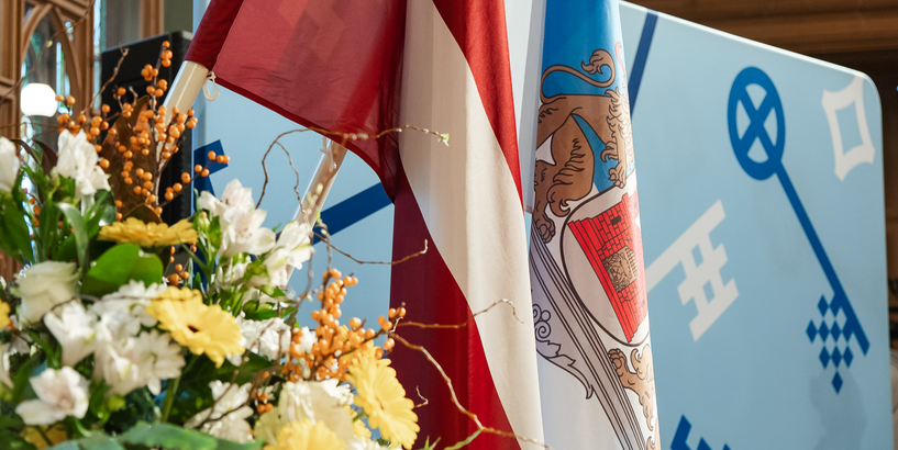 Latvijas valsts un Rīgas pašvaldības karogi pasākuma zālē 