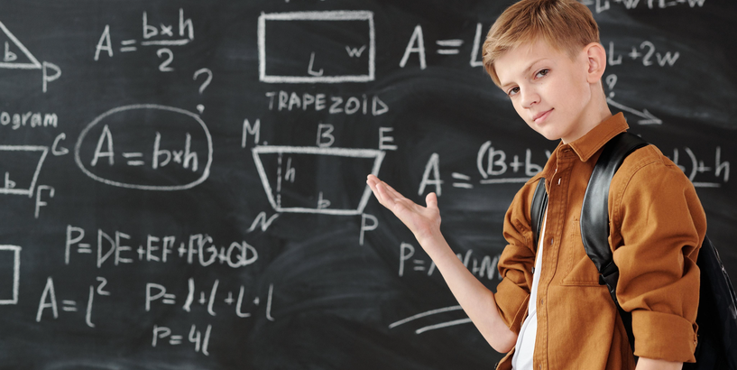 Zēns pie tāfeles ar matemātiskām formulām