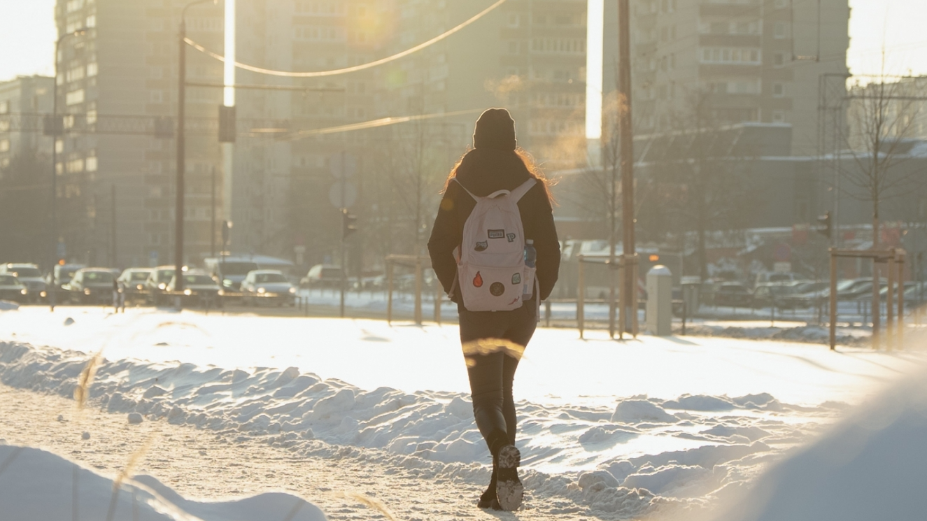 Meitene ar mugursomu plecā Rīgas mikrorajonā