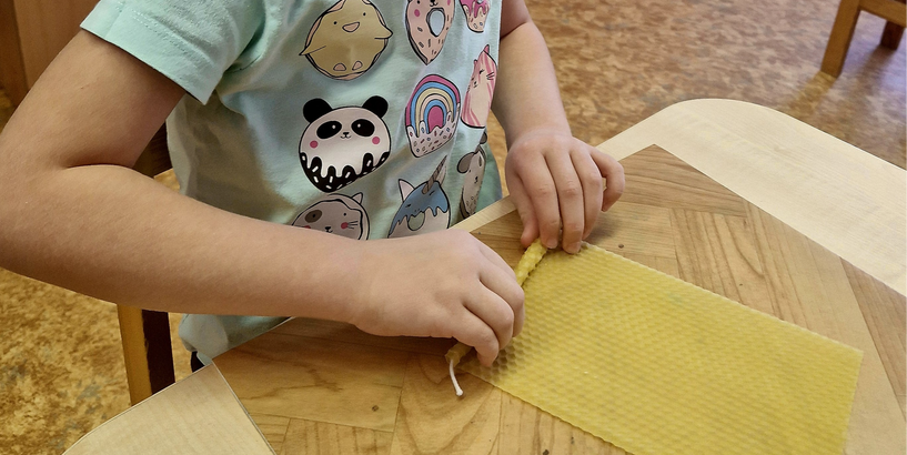 Bērns no bišu vaska šūnu plāksnes tin sveci