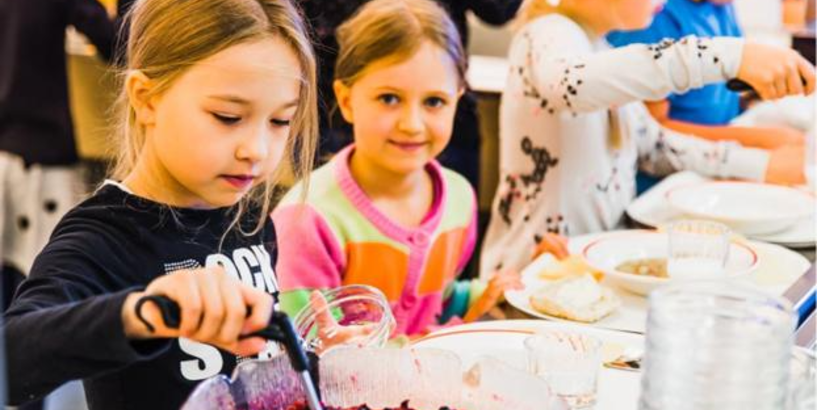 Bērni pusdieno skolas ēdnīcā